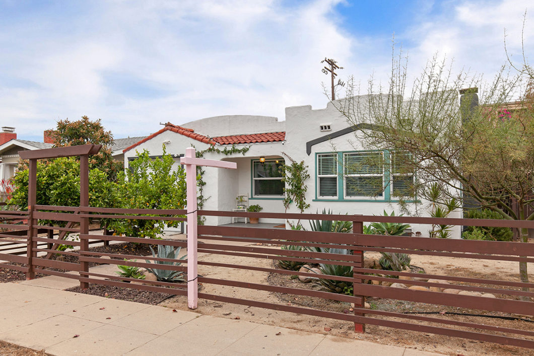 wood fence in front of landscape and front of house