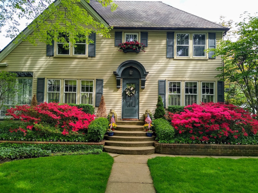 A beautiful front lawn of a home in San Diego with fresh green grass and red flowers