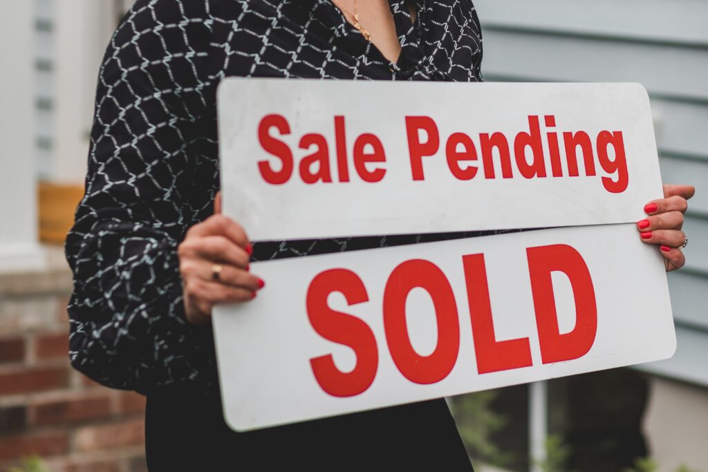 a person holding a sold sign