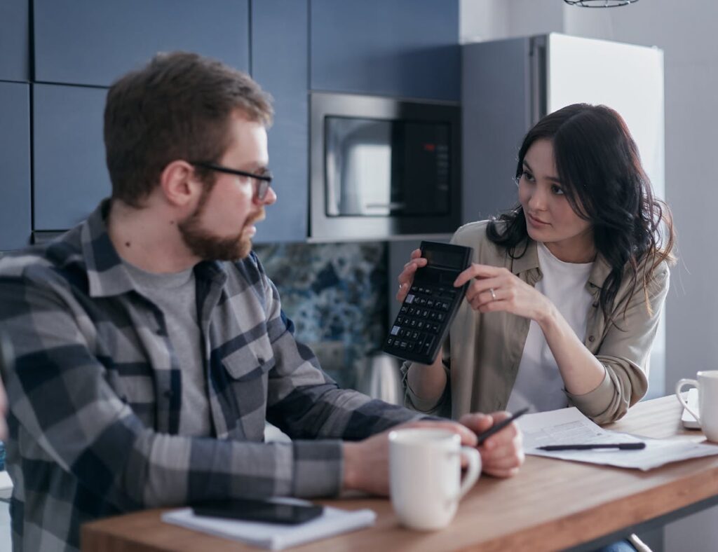 Overpricing a Home - A Woman Showing a Man a Calculator