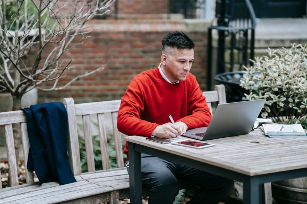 A Man in a Red Jacket Doing Remote Work