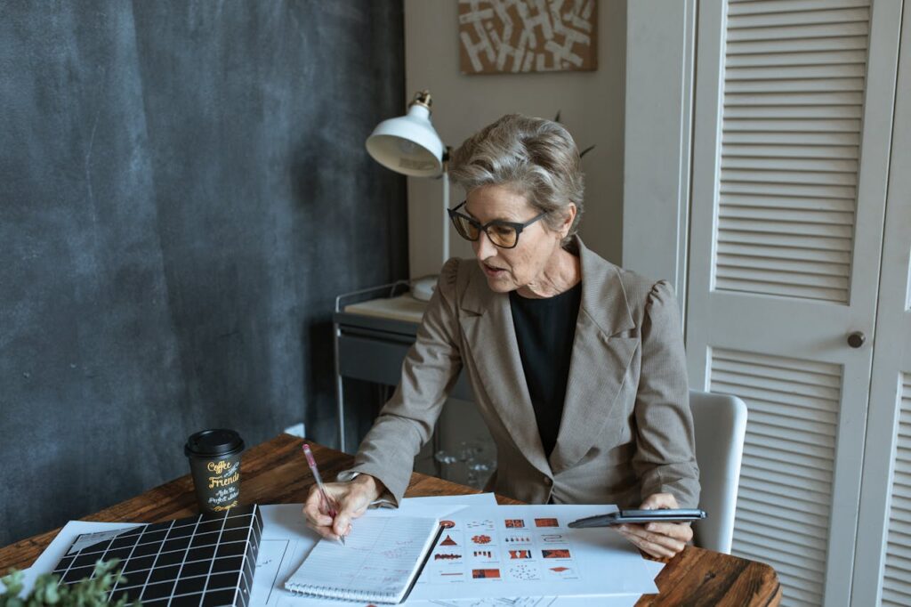 A Woman Taking Down Notes and Hold a Calculator