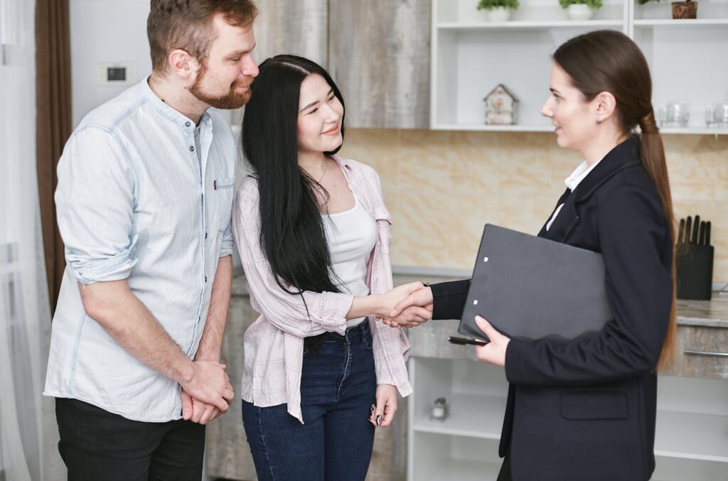 A Realtor and Her Clients Shaking Hands
