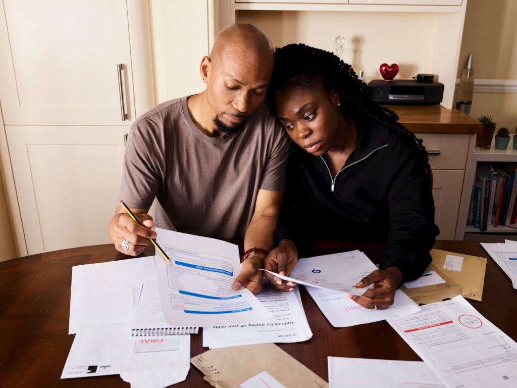 A Couple Sitting by the Table Looking Over Bills