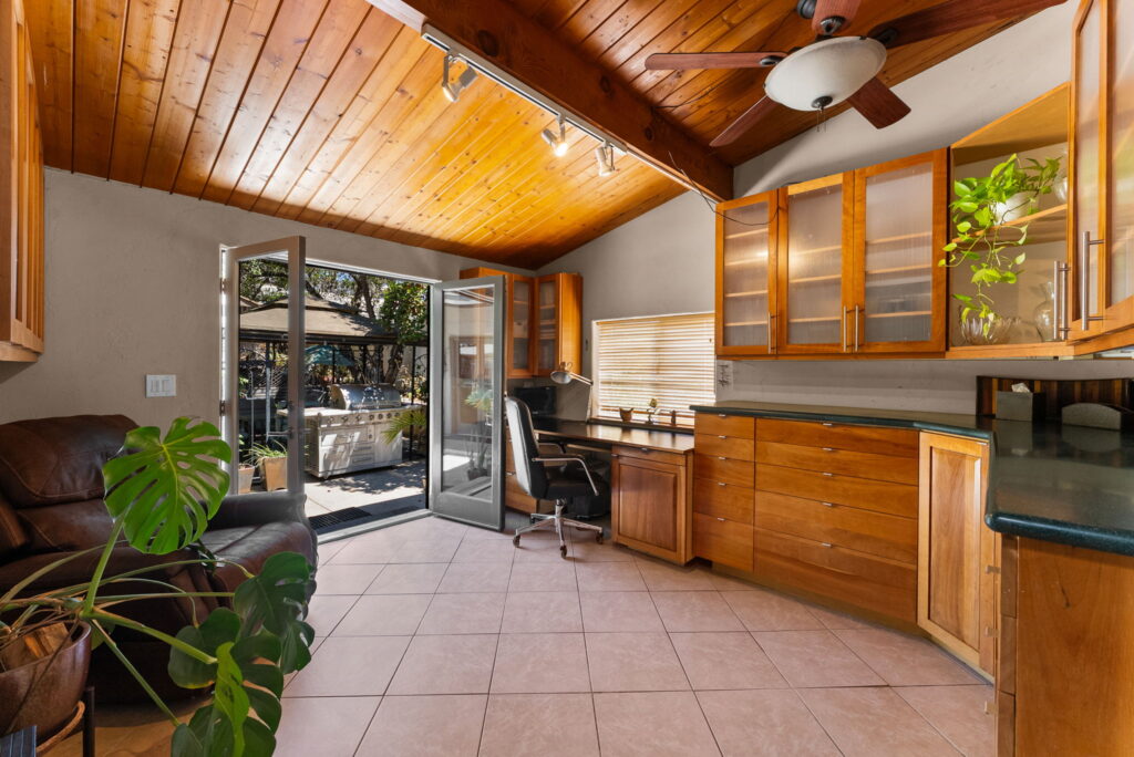 room set as an office with maple colored cabinets and french doors leading outside