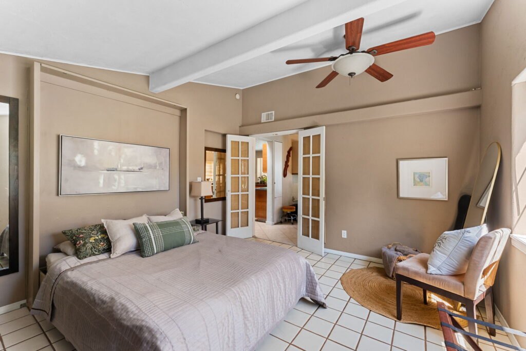 bedroom with light colored bedding and french doors