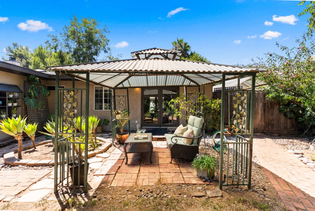 side of home with outdoor seating under pergola and views of french doors