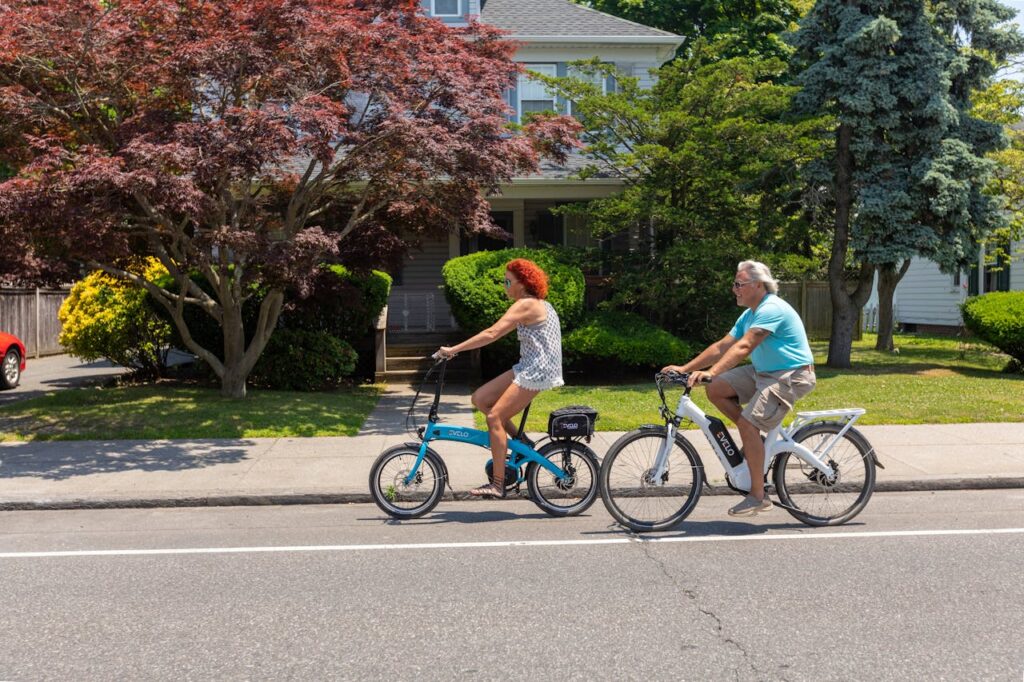 A Couple Riding their Bikes Down a Street