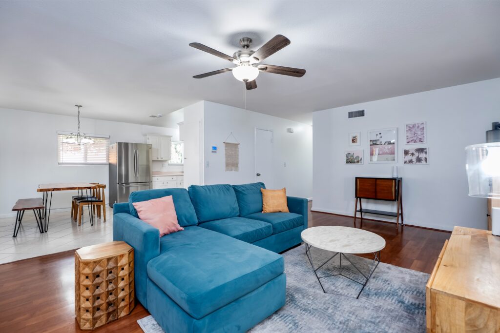 Open-concept living room and kitchen at 2170 Montclair St in North Park featuring painted cabinetry, stainless steel appliances, and seamless flow between living spaces.
