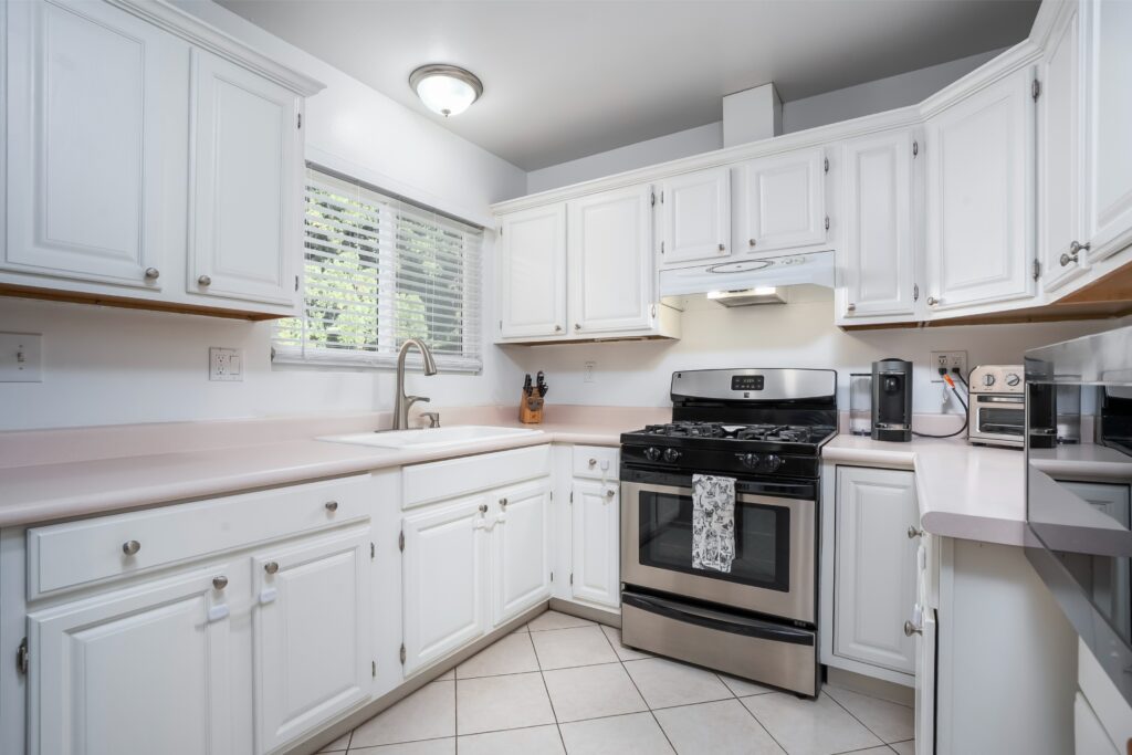 Open concept kitchen at 2170 Montclair St North Park featuring white cabinetry, stone countertops, and stainless steel appliances.