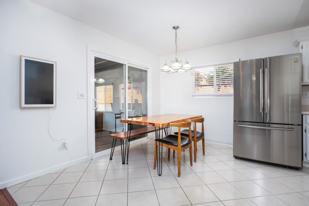 Kitchen interior at 2170 Montclair St in North Park highlighting the refrigerator and wooden dining table set.