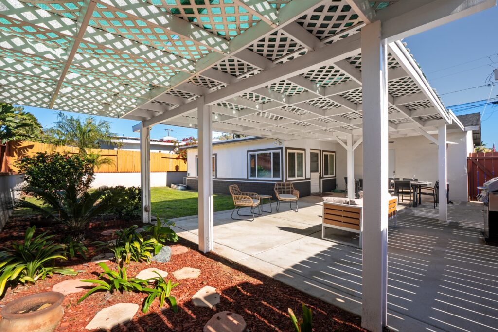 Large white lattice pergola and concrete patio at 2170 Montclair St, highlighting the San Diego lifestyle with professional landscaping and a secluded retreat feel.