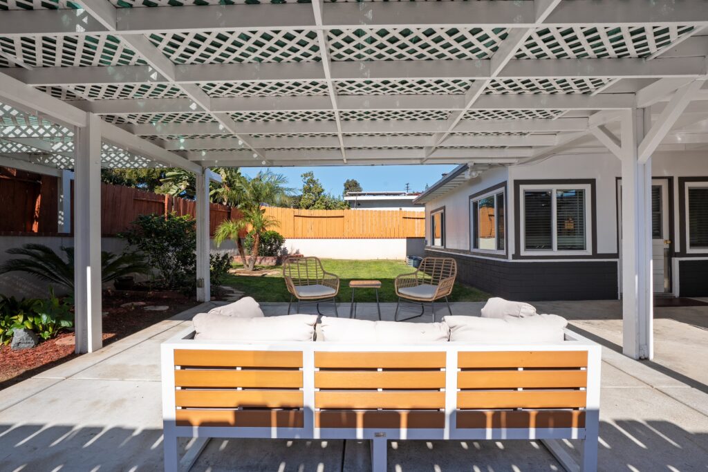 Modern backyard lounge area at 2170 Montclair St in North Park San Diego, featuring stylish outdoor sofas and a spacious lawn for pets and children.