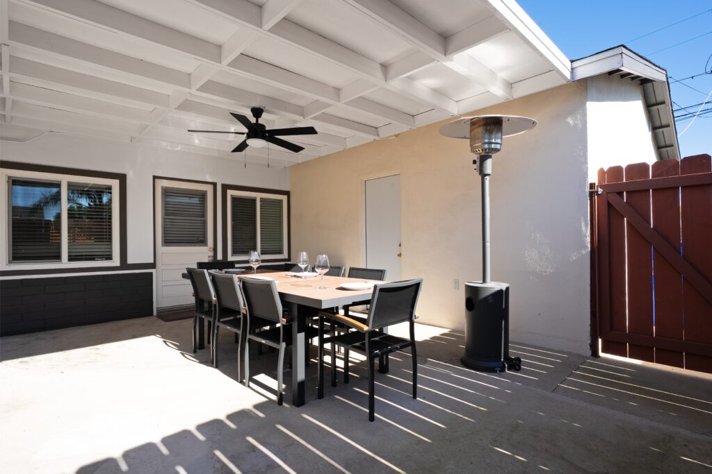 Exterior patio of 2170 Montclair St North Park home for sale, showing high-end outdoor space heater and modern dining set under a shaded terrace.
