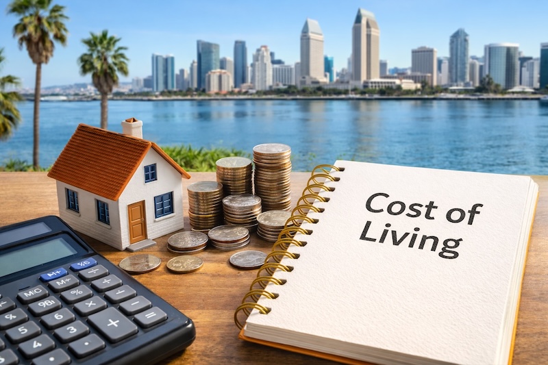 Cost of living in San Diego illustrated with model home, calculator, and stacked coins against the San Diego skyline